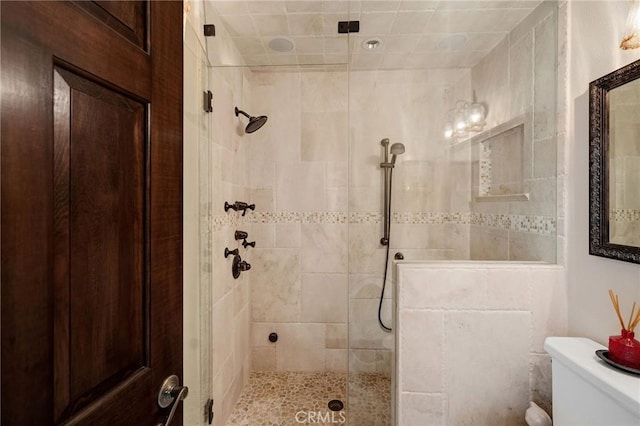 full bath with toilet and a tile shower