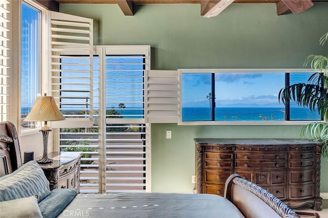 interior space featuring beam ceiling and a water view