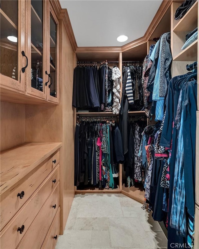 walk in closet featuring stone finish flooring