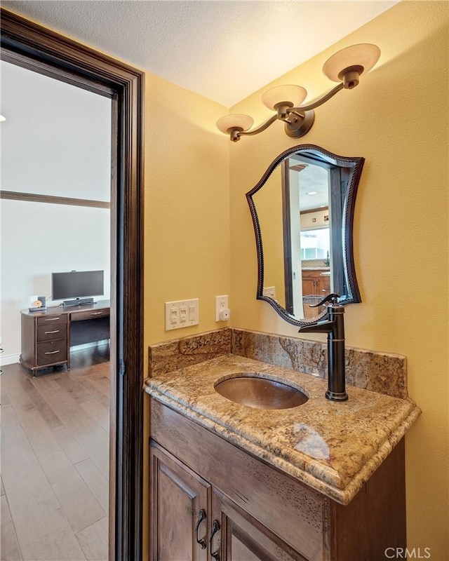 bathroom featuring vanity, wood finished floors, and a textured ceiling