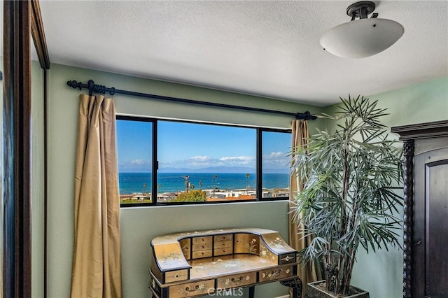 dining area with a textured ceiling and a water view