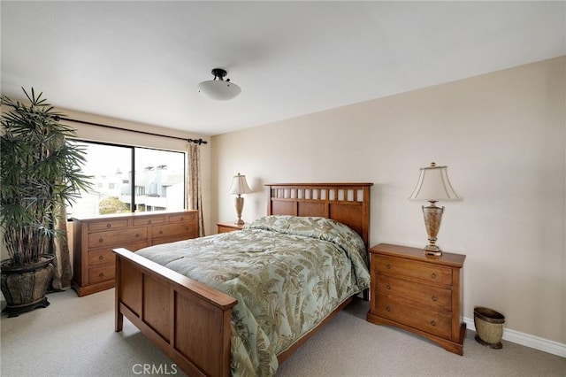 bedroom featuring baseboards and light carpet