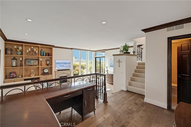 dining space featuring dark wood-type flooring, stairway, a fireplace, crown molding, and baseboards