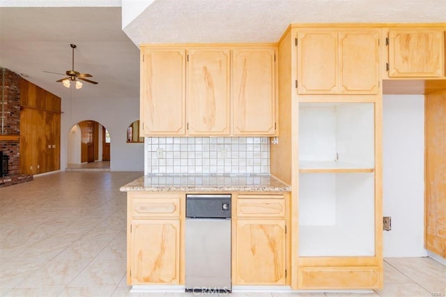 kitchen featuring light tile patterned floors, arched walkways, ceiling fan, and light brown cabinets