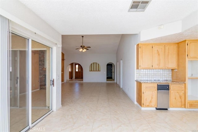 kitchen featuring visible vents, light brown cabinetry, arched walkways, light countertops, and ceiling fan