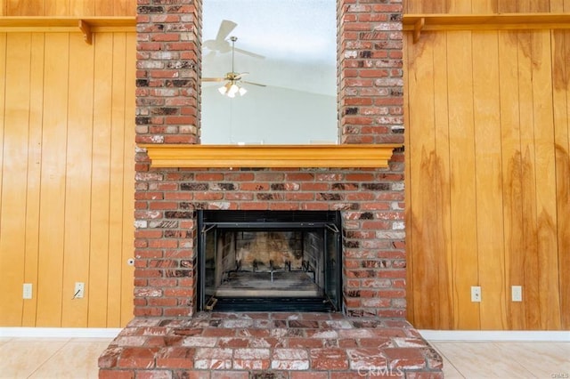 room details featuring a fireplace, wooden walls, and a ceiling fan
