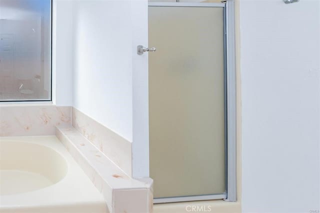 full bath featuring a shower with door and a garden tub