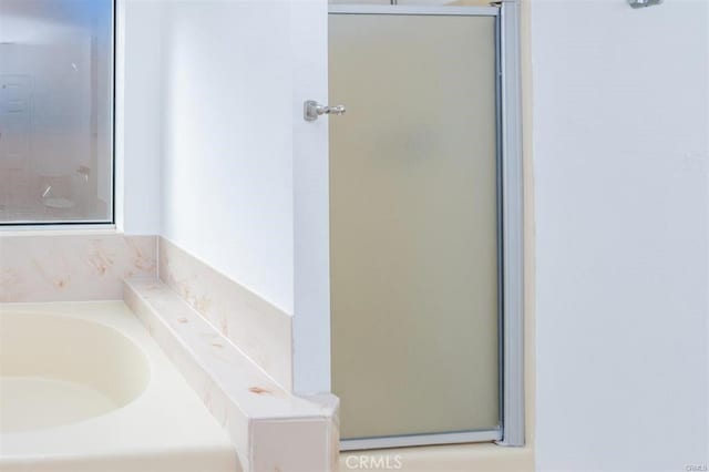 bathroom with an enclosed shower and a garden tub