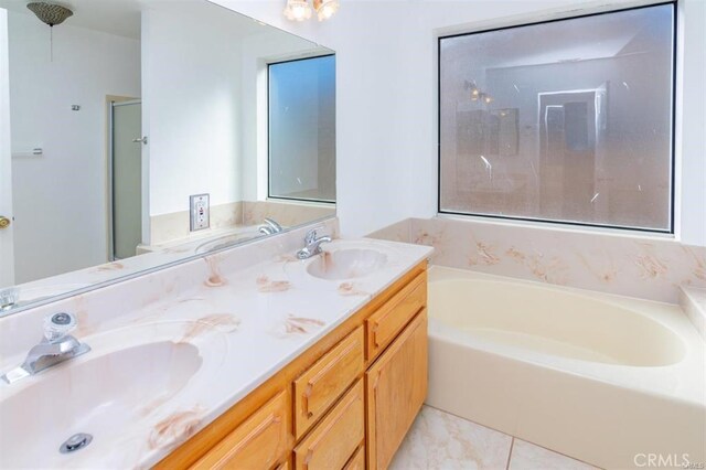 full bath with double vanity, a sink, and a garden tub