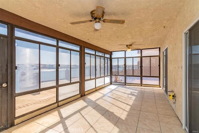 unfurnished sunroom featuring a ceiling fan