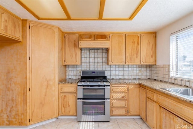 kitchen with a sink, backsplash, double oven range, custom exhaust hood, and light tile patterned floors