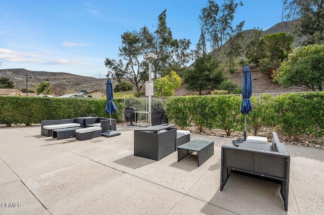 view of patio / terrace featuring outdoor lounge area, fence, and a mountain view