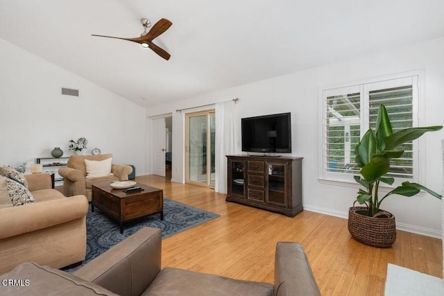 living room featuring ceiling fan, wood finished floors, visible vents, baseboards, and vaulted ceiling