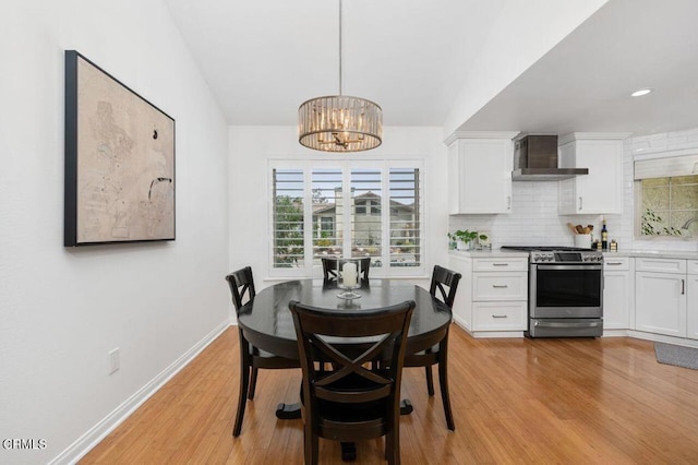 dining area with a chandelier, recessed lighting, light wood-style flooring, and baseboards