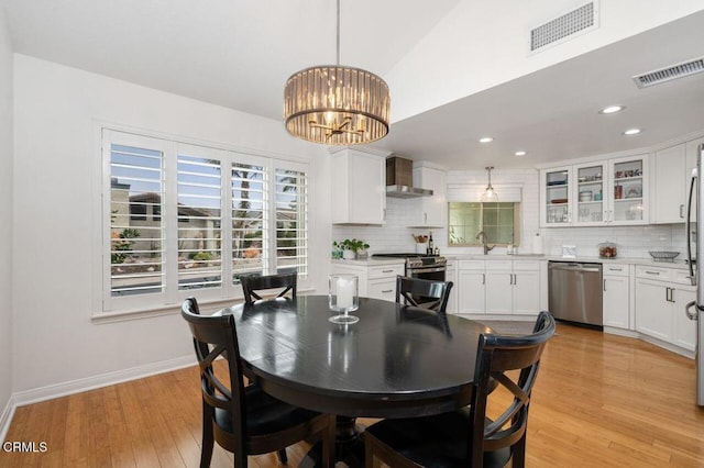 dining space with baseboards, light wood-style floors, recessed lighting, and a chandelier