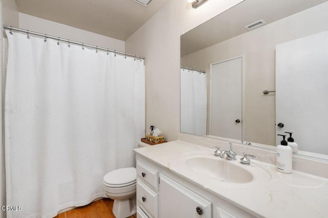 full bathroom with toilet, vanity, and wood finished floors