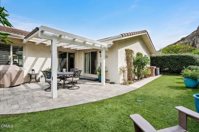 back of house with stucco siding, a pergola, a yard, and a tile roof