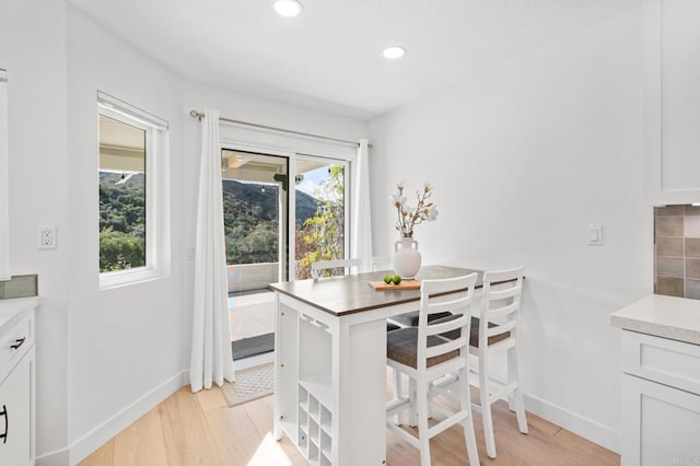 dining room with baseboards, recessed lighting, and light wood-style floors