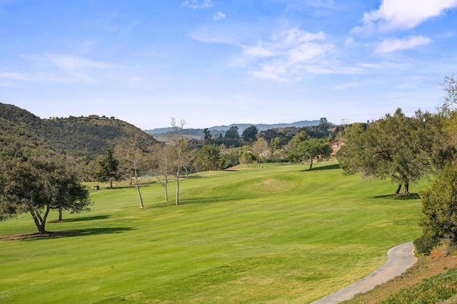 view of property's community featuring a mountain view, golf course view, and a yard