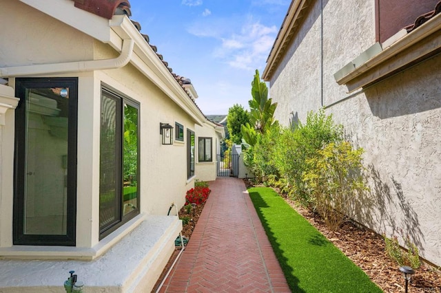 view of side of property featuring fence and stucco siding