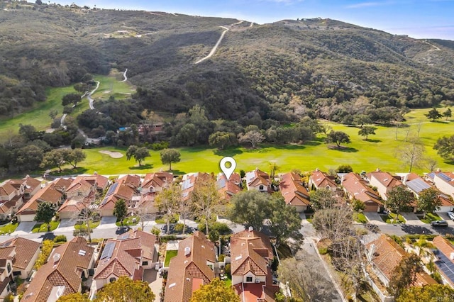 drone / aerial view with a residential view, a mountain view, and golf course view