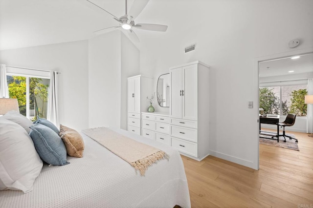 bedroom with ceiling fan, high vaulted ceiling, visible vents, baseboards, and light wood-type flooring