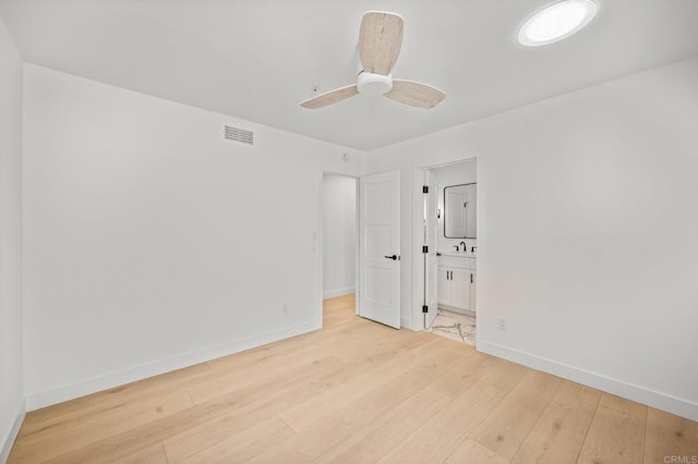 spare room featuring light wood-style floors, ceiling fan, and baseboards