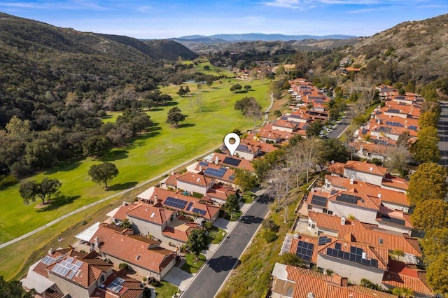 drone / aerial view featuring view of golf course, a residential view, and a mountain view