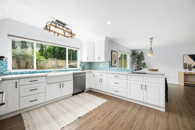 kitchen featuring light wood-type flooring, stainless steel dishwasher, decorative backsplash, and light countertops