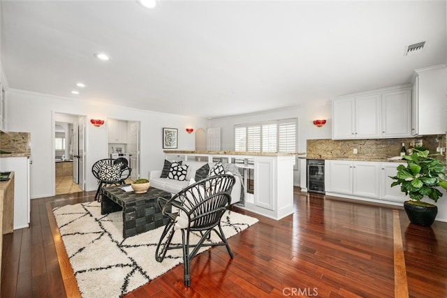 dining area with visible vents, dark wood finished floors, recessed lighting, wine cooler, and crown molding