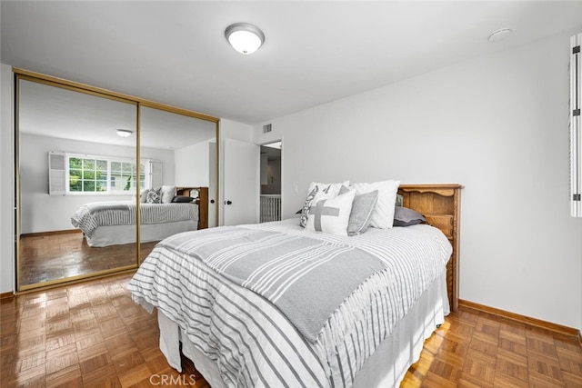 bedroom with a closet, visible vents, and baseboards