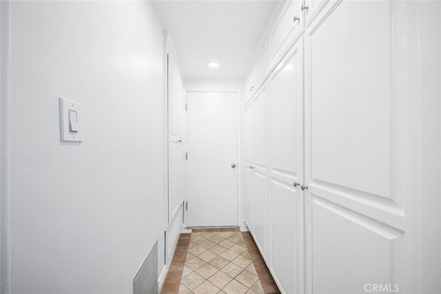 hall featuring light tile patterned floors and recessed lighting