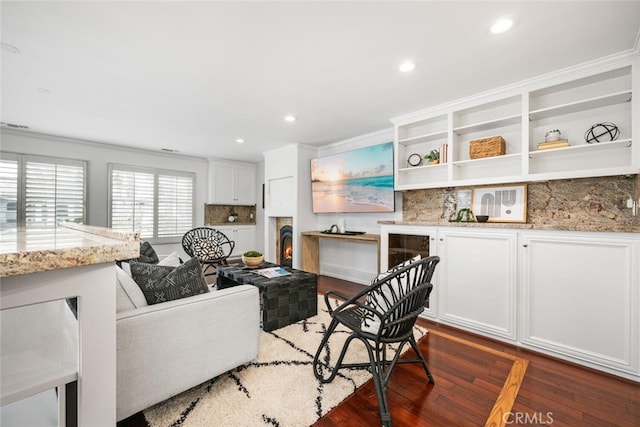 living room with recessed lighting, a lit fireplace, and wood finished floors