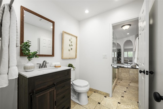 bathroom with recessed lighting, toilet, vanity, and walk in shower