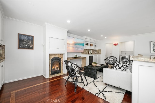 living room with a fireplace with flush hearth, hardwood / wood-style floors, and crown molding