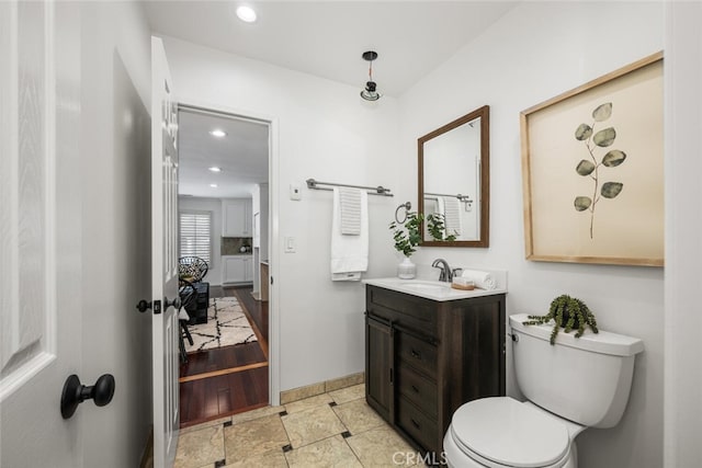 bathroom with recessed lighting, baseboards, toilet, and vanity