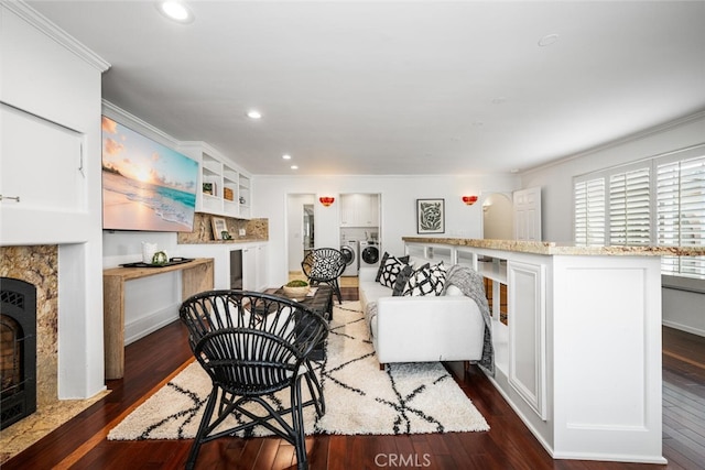 living area featuring crown molding, recessed lighting, dark wood-style floors, and a premium fireplace