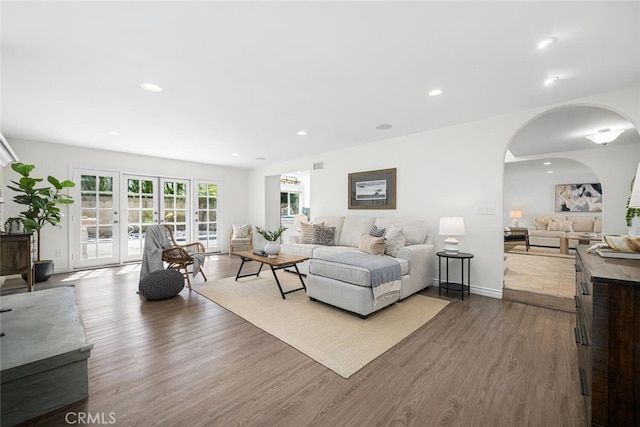 living room with baseboards, recessed lighting, dark wood-style flooring, and arched walkways