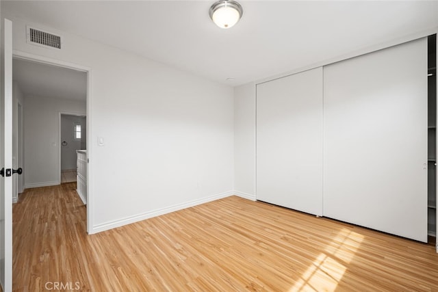 unfurnished bedroom with light wood-style flooring, baseboards, and visible vents