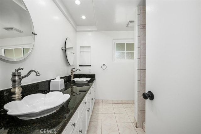 bathroom featuring double vanity, visible vents, tile patterned floors, and a sink