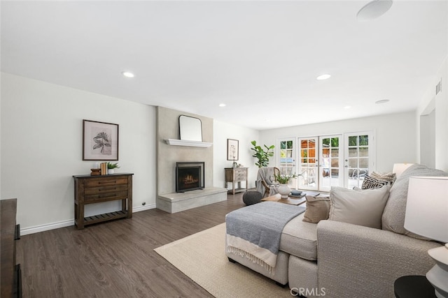 living room with baseboards, recessed lighting, french doors, a fireplace, and dark wood-style floors