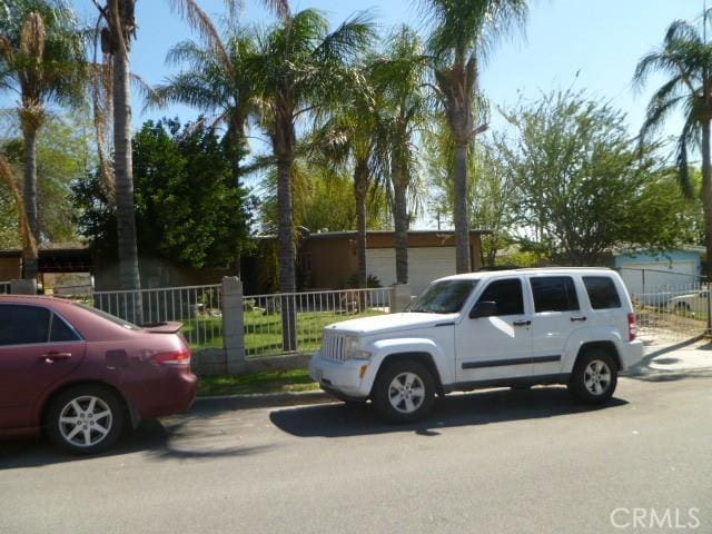 view of vehicle parking with fence