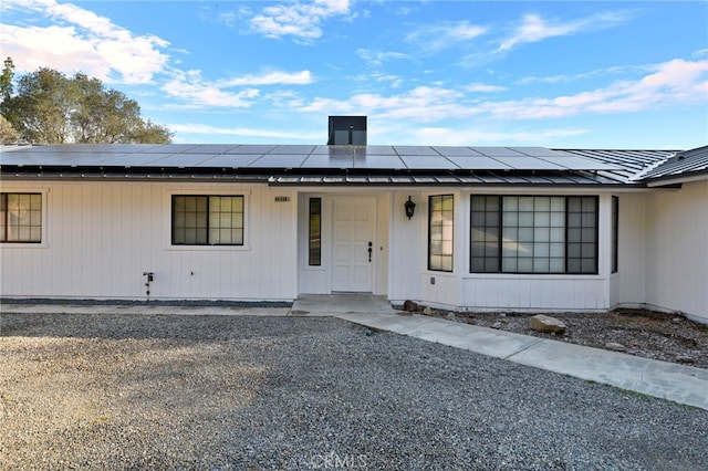 view of front of property with a porch, roof mounted solar panels, and metal roof