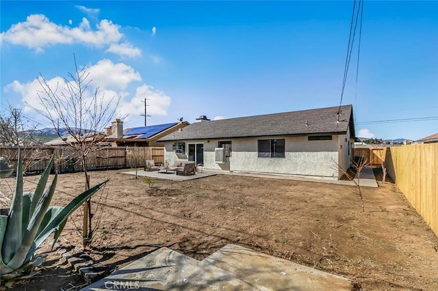 rear view of house with a fenced backyard, a patio, and stucco siding