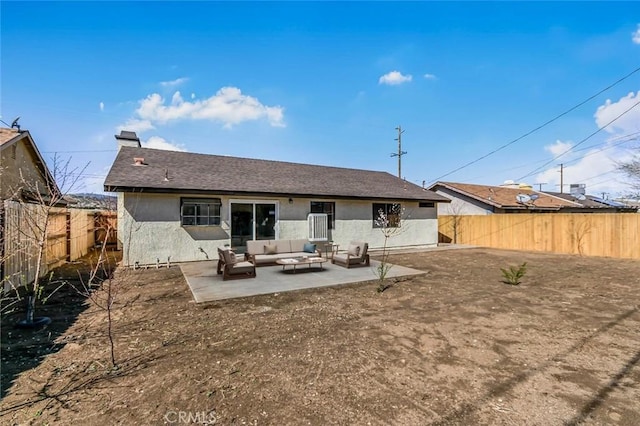 back of property featuring a fenced backyard, an outdoor hangout area, roof with shingles, stucco siding, and a patio area