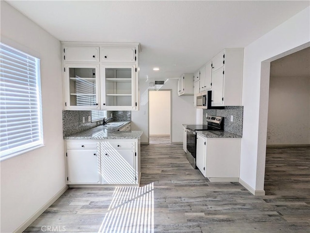 kitchen featuring a sink, white cabinetry, stainless steel appliances, and decorative backsplash