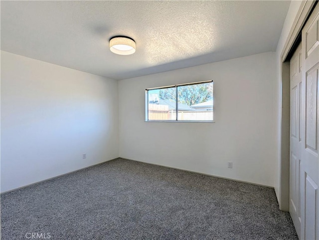 carpeted spare room featuring a textured ceiling