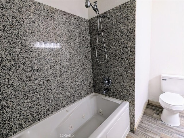 bathroom featuring a combined bath / shower with jetted tub, wood finished floors, and toilet