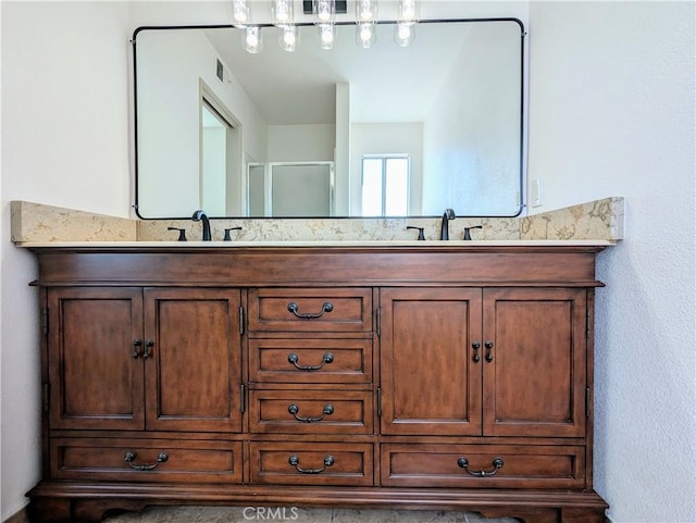 full bathroom with double vanity, a sink, and a shower with shower door