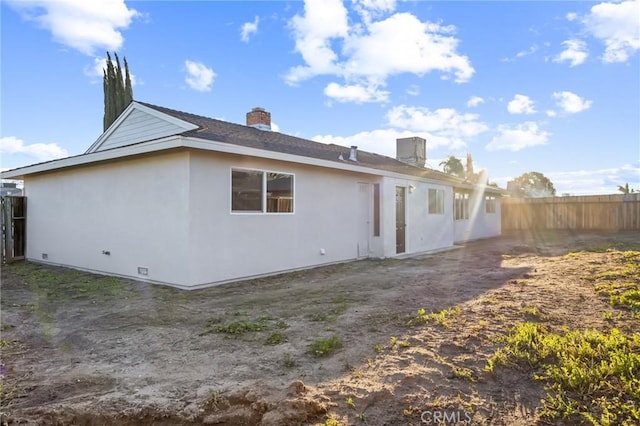 back of property featuring fence and stucco siding